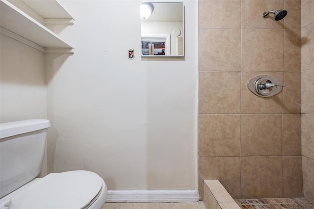 bathroom with tiled shower and toilet