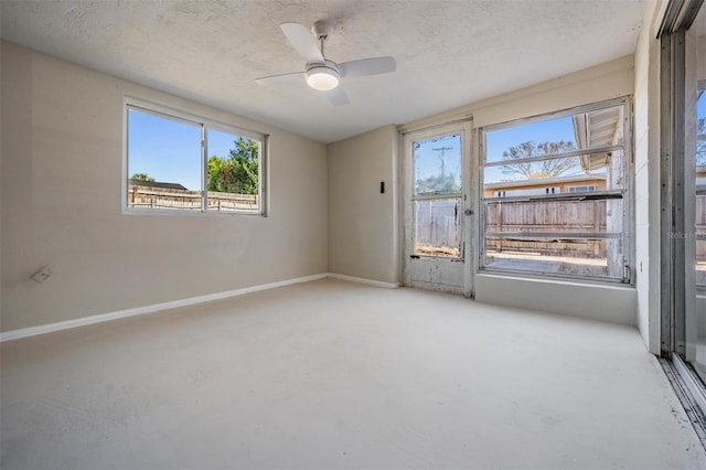 spare room with ceiling fan, a healthy amount of sunlight, and a textured ceiling