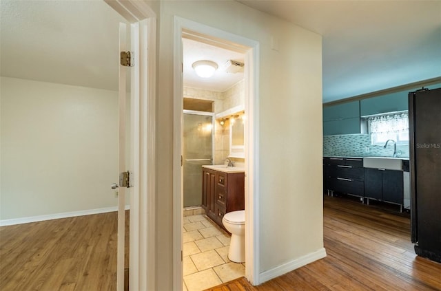 bathroom with toilet, hardwood / wood-style flooring, backsplash, and vanity