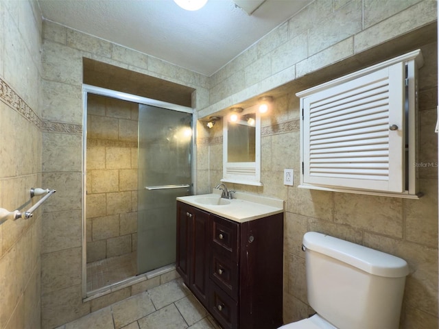 bathroom featuring a textured ceiling, toilet, walk in shower, and vanity