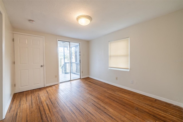 unfurnished room featuring wood-type flooring and a textured ceiling