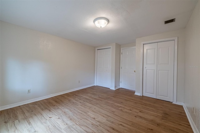 unfurnished bedroom with hardwood / wood-style floors and a textured ceiling