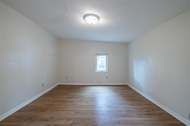 spare room with a textured ceiling and hardwood / wood-style flooring