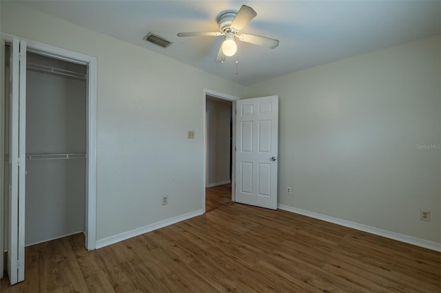 unfurnished bedroom featuring ceiling fan, a closet, and hardwood / wood-style floors