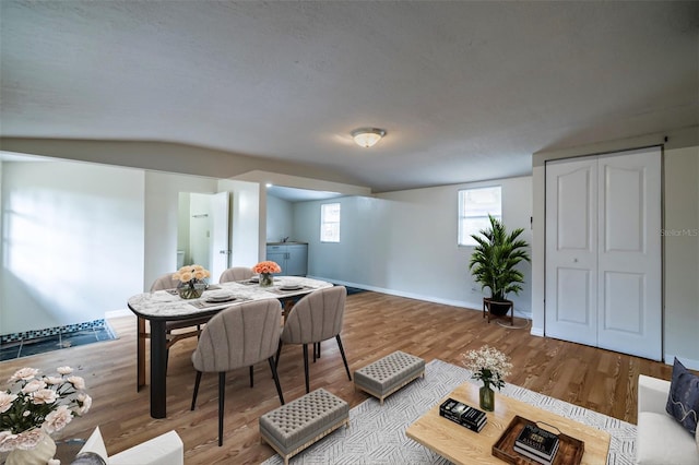 dining area featuring hardwood / wood-style flooring and vaulted ceiling