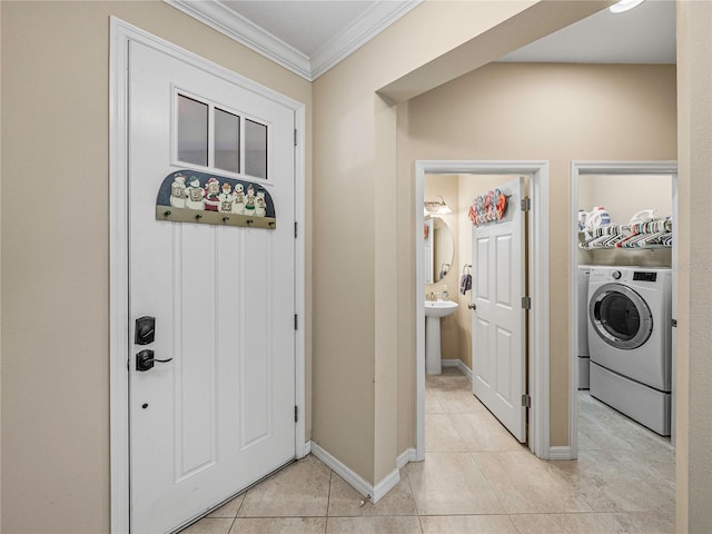 laundry area featuring crown molding, sink, light tile patterned floors, and washer / dryer