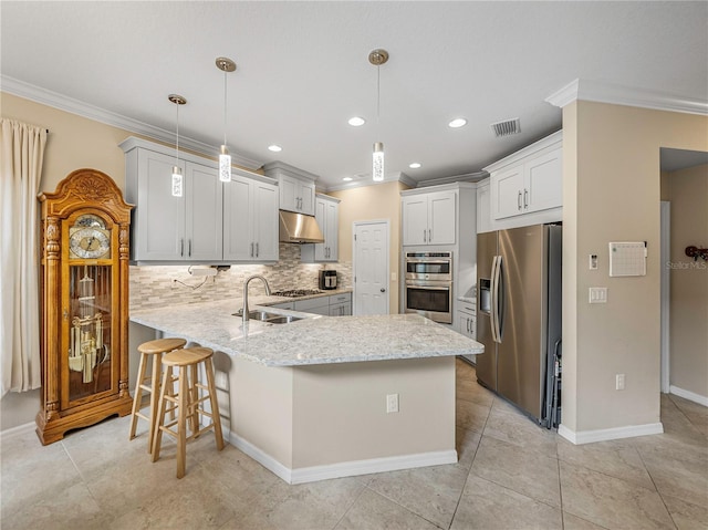 kitchen featuring kitchen peninsula, appliances with stainless steel finishes, ornamental molding, sink, and decorative light fixtures