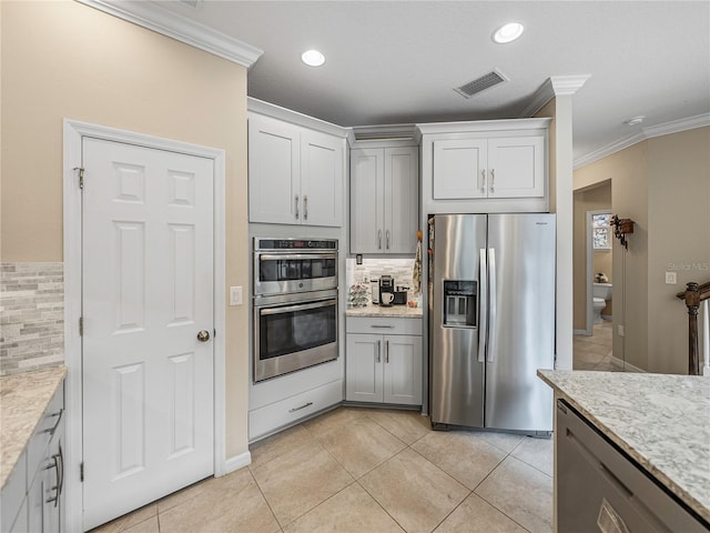 kitchen featuring light stone countertops, tasteful backsplash, crown molding, light tile patterned floors, and appliances with stainless steel finishes