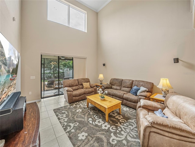 living room with a high ceiling, light tile patterned floors, and ornamental molding