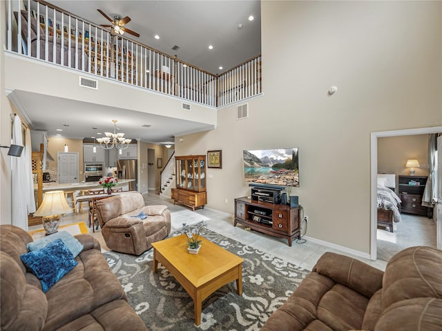 tiled living room featuring ceiling fan with notable chandelier and a high ceiling