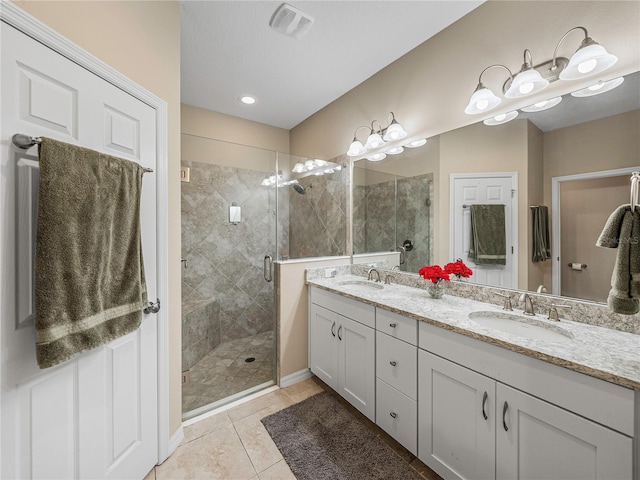 bathroom featuring tile patterned flooring, vanity, and a shower with shower door