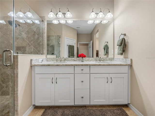 bathroom featuring tile patterned floors, vanity, and a shower with shower door