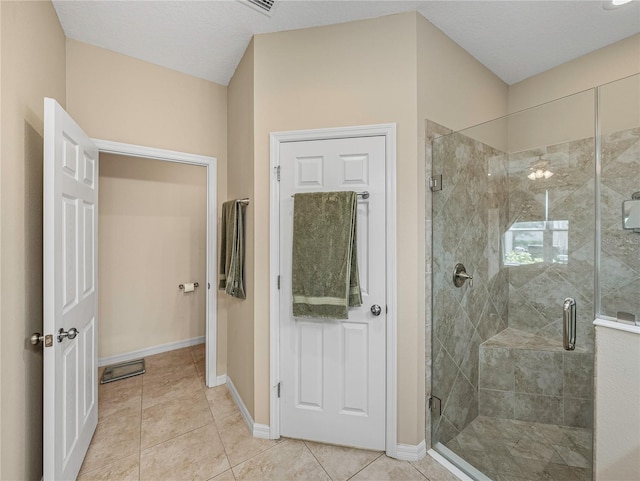 bathroom featuring tile patterned flooring, walk in shower, and a textured ceiling