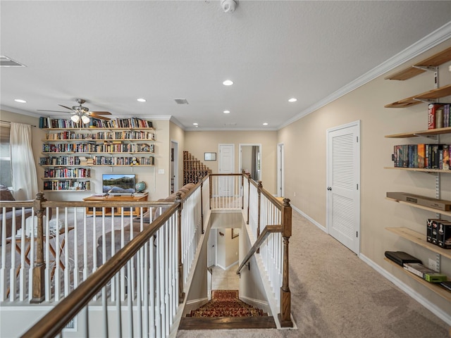 hallway with crown molding, carpet floors, and a textured ceiling