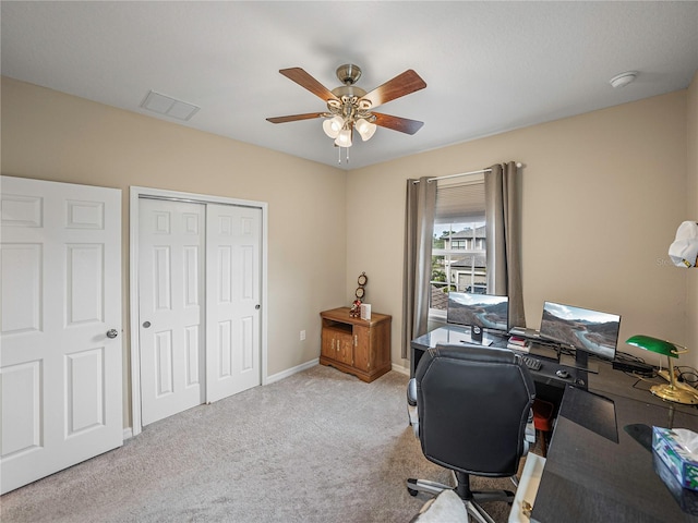 home office with ceiling fan and light carpet