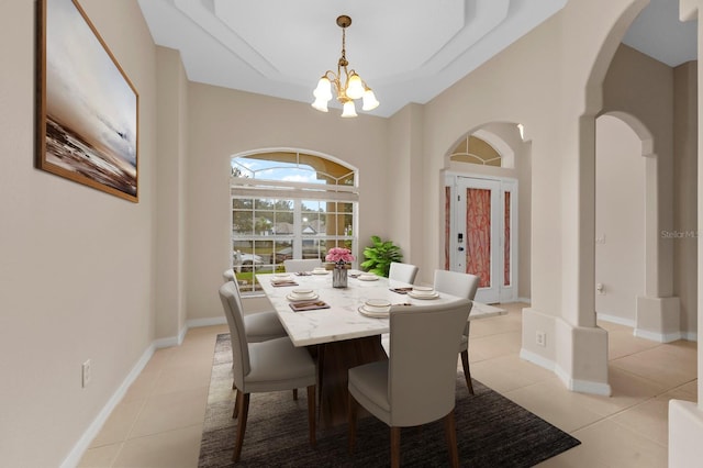 dining room with light tile patterned floors and an inviting chandelier