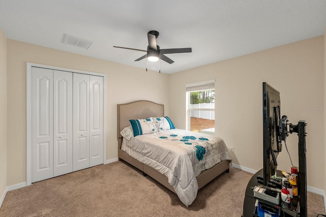 bedroom with a closet, ceiling fan, and light colored carpet