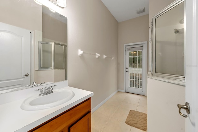 bathroom featuring tile patterned flooring, vanity, and an enclosed shower