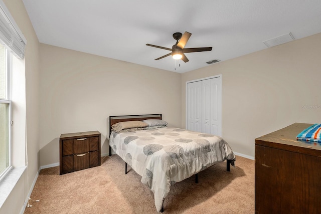 carpeted bedroom with ceiling fan and a closet