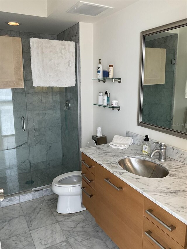 bathroom with vanity, an enclosed shower, and toilet