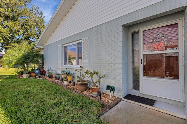 view of exterior entry with a yard