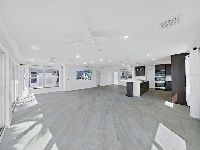 unfurnished living room featuring ceiling fan and light hardwood / wood-style floors