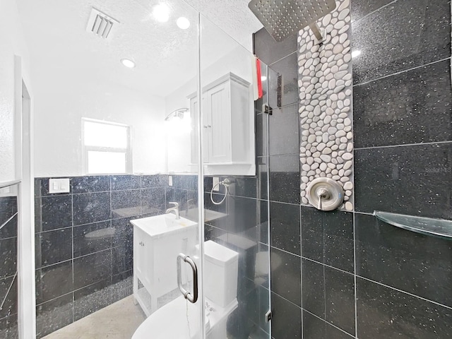 bathroom featuring vanity, a shower with door, and tile walls