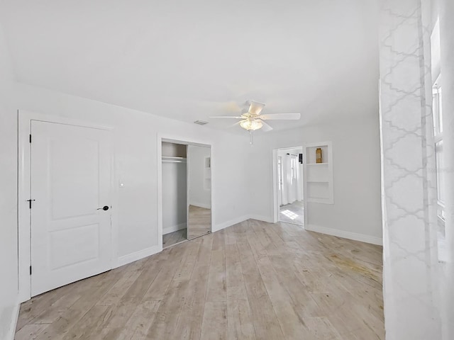 interior space featuring connected bathroom, ceiling fan, a closet, and light wood-type flooring