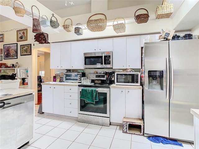 kitchen featuring stainless steel appliances, white cabinetry, and light tile patterned flooring