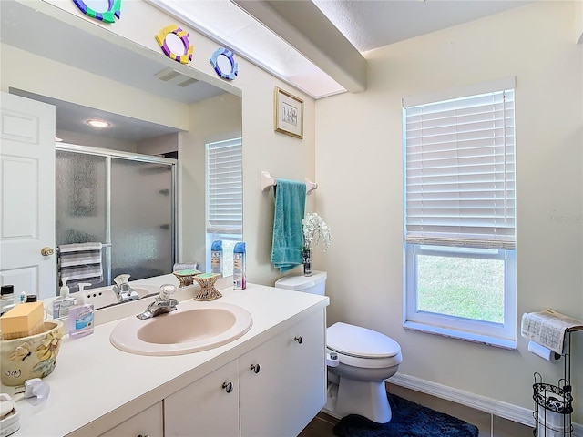 bathroom with tile patterned floors, vanity, an enclosed shower, and toilet