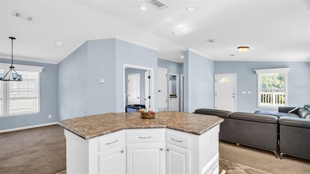 kitchen with a center island, light colored carpet, white cabinetry, and hanging light fixtures