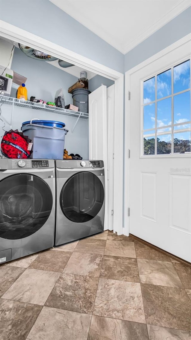 washroom with ornamental molding and washing machine and clothes dryer