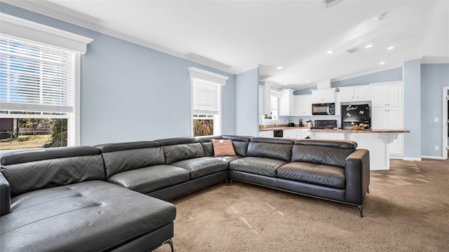 carpeted living room featuring ornamental molding, lofted ceiling, and a healthy amount of sunlight