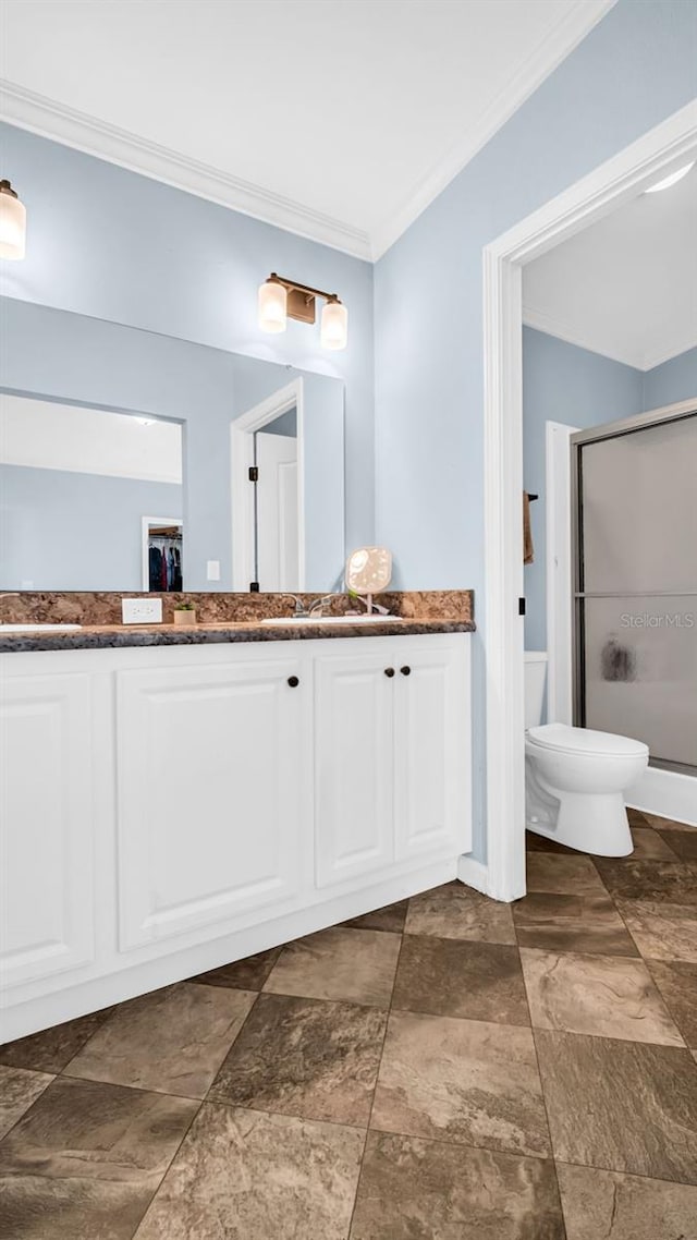 bathroom with vanity, toilet, an enclosed shower, and ornamental molding