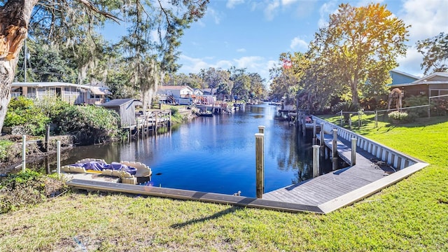 dock area with a yard and a water view