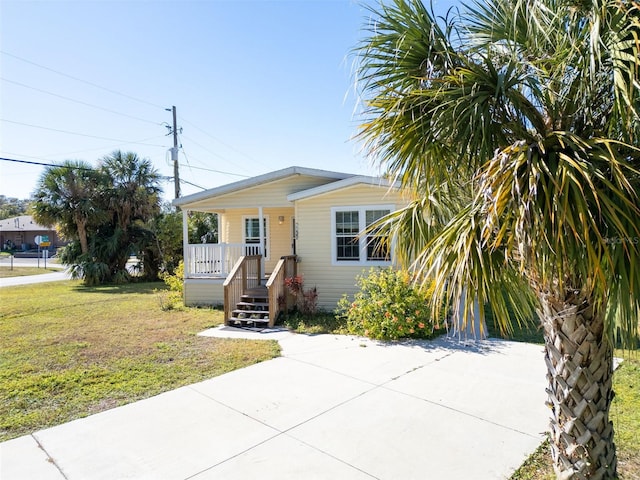 view of front of house featuring covered porch and a front yard