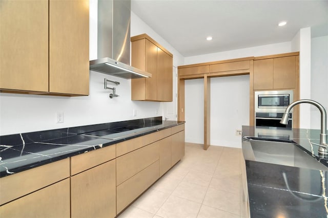 kitchen featuring sink, wall chimney exhaust hood, light tile patterned floors, and appliances with stainless steel finishes