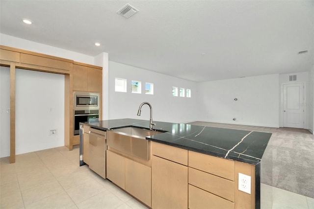 kitchen featuring light brown cabinets, stainless steel appliances, a kitchen island with sink, and sink