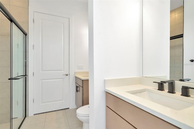 bathroom featuring tile patterned floors, walk in shower, vanity, and toilet