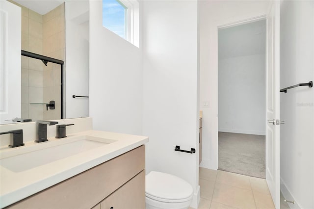 bathroom with tile patterned flooring, vanity, toilet, and walk in shower