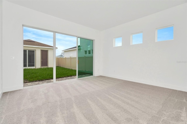 empty room featuring a wealth of natural light and carpet floors