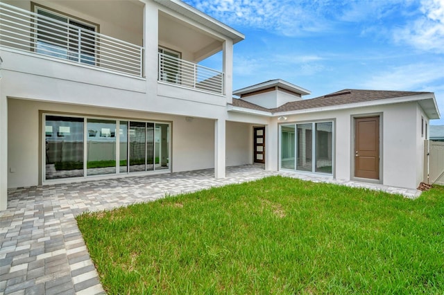 back of house with a yard, a balcony, and a patio area