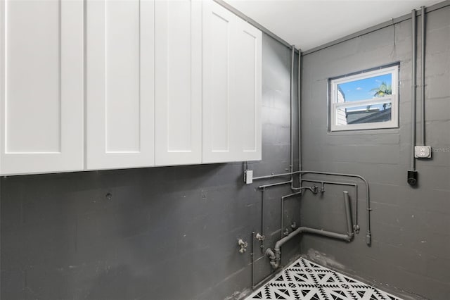 laundry area featuring cabinets and tile patterned flooring