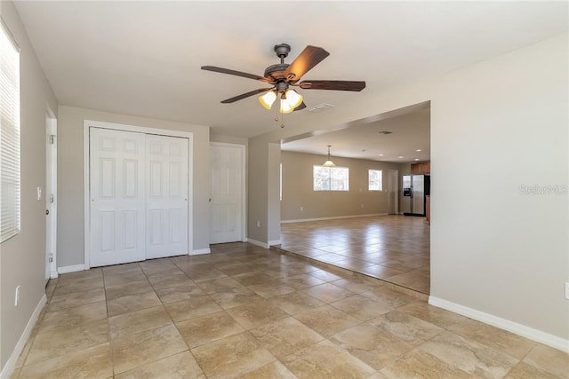 tiled spare room with ceiling fan