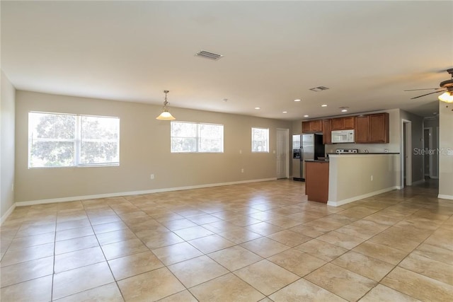 kitchen with stainless steel fridge, light tile patterned floors, pendant lighting, and ceiling fan