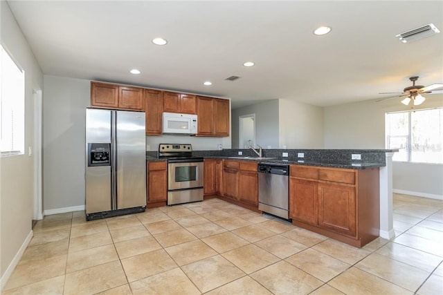 kitchen with kitchen peninsula, appliances with stainless steel finishes, ceiling fan, sink, and light tile patterned floors