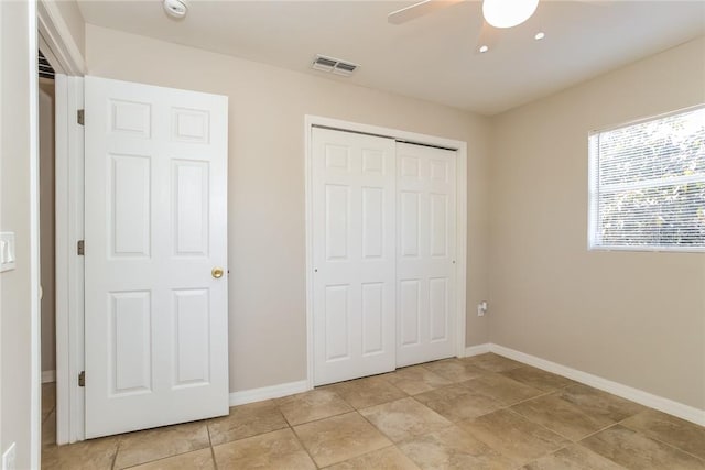 unfurnished bedroom with ceiling fan and a closet