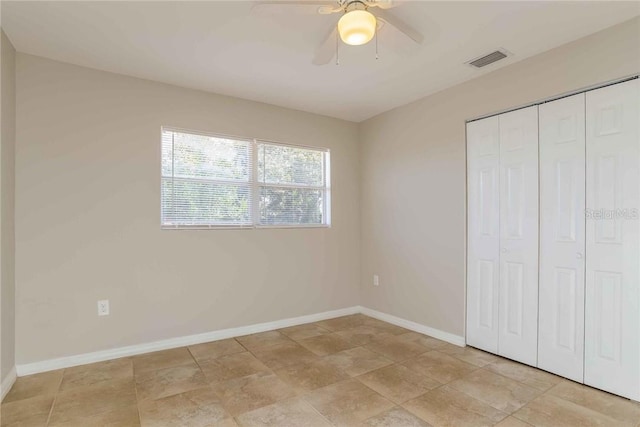 unfurnished bedroom featuring ceiling fan and a closet