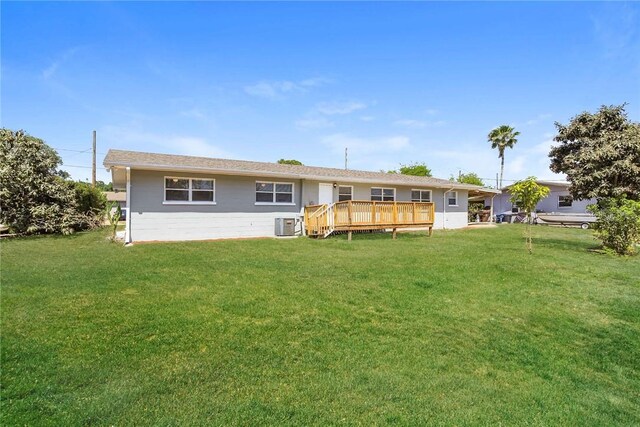 rear view of house with a yard, central AC, and a wooden deck