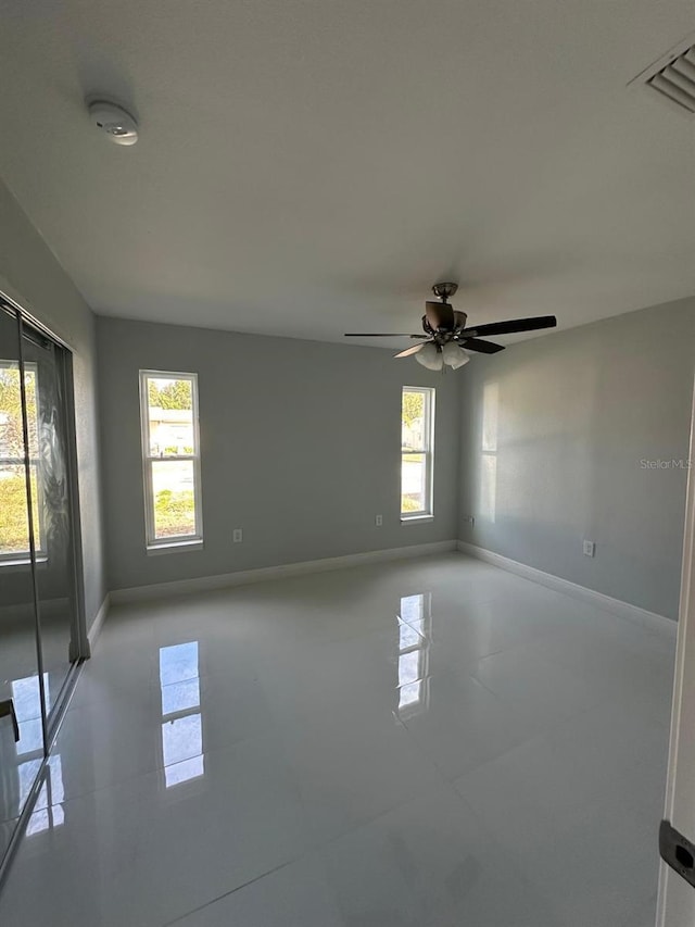 tiled empty room with ceiling fan